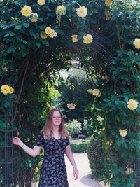 Woman standing by flower plants