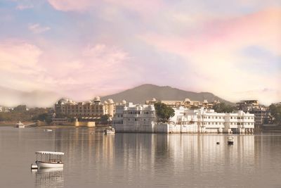 Scenic view of river by buildings against sky