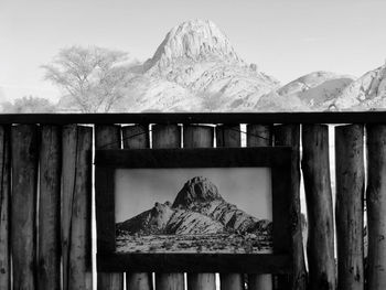 Built structure by snowcapped mountains against sky