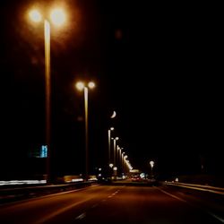 Illuminated street lights on road at night