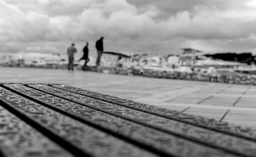 Surface level view of wet bench on promenade against sky
