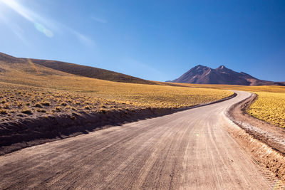 Road amidst desert against sky