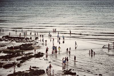 People at beach against sky