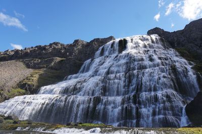 Scenic view of waterfall against sky