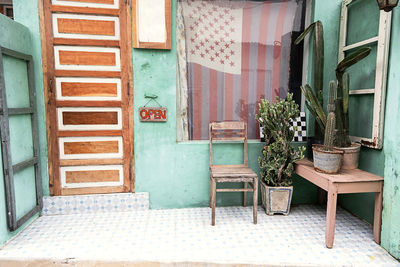 Old chair and cacti near front door of small vintage country store.