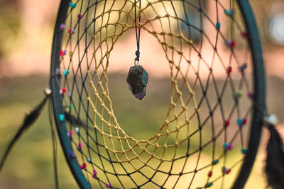 Close-up of fishing net hanging on metal fence