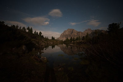 Scenic view of lake against sky at night