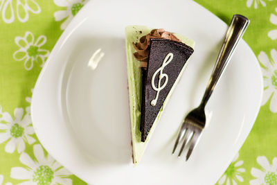 Directly above shot of cake slice and fork in plate on table