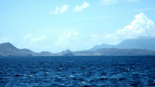 Scenic view of sea and mountains against sky