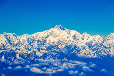 Scenic view of snowcapped mountains against clear blue sky