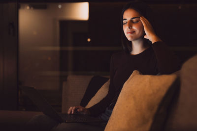 Portrait of young woman sitting at home