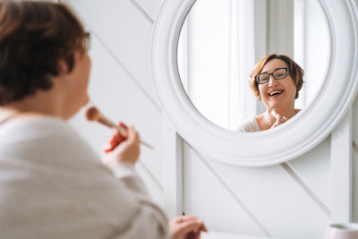 Side view of woman washing hands in bathroom