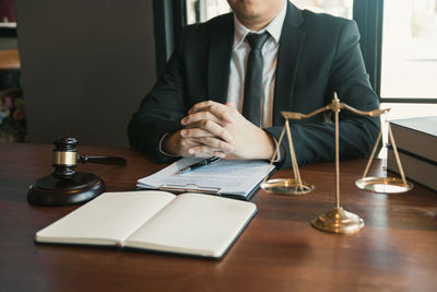 Midsection of man sitting on table