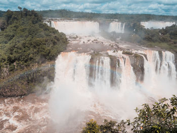 Scenic view of waterfall against sky