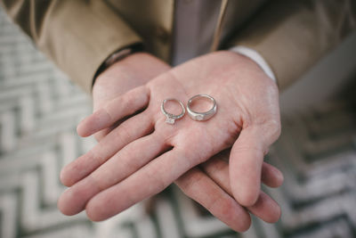 Midsection of bride holding wedding rings