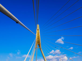 Low angle view of suspension bridge against sky