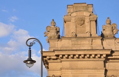 Low angle view of statue against building against sky