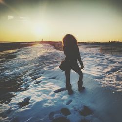 Silhouette of person standing on snow covered road