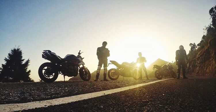 motorcycle, adult, only men, transportation, men, riding, adults only, rear view, adventure, people, silhouette, sunlight, motocross, real people, sport, clear sky, motorsport, outdoors, day, friendship, competition, sky, togetherness, full length, extreme sports, sports track, headwear, tree, biker, young adult