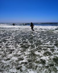 Man on beach against clear sky