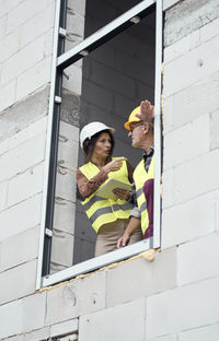 Low angle view of engineers talking at window