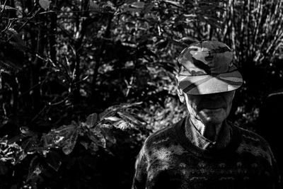 Portrait of old men standing by tree in forest