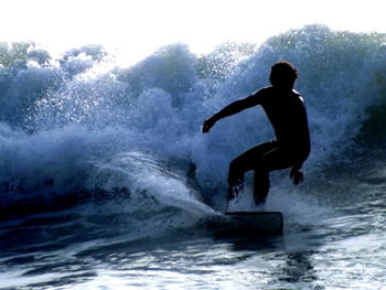 Silhouette man in sea against clear sky