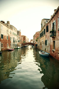 Canal amidst buildings against sky