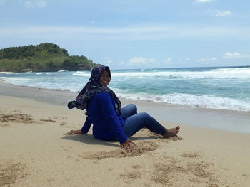 Full length of man sitting on beach