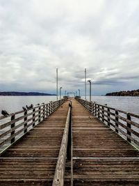 Empty pier over sea against sky