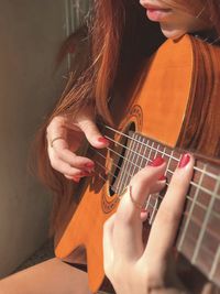 Midsection of woman playing guitar