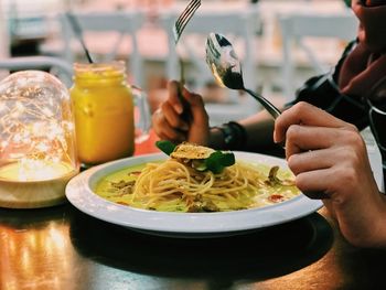 Midsection of person having food in restaurant