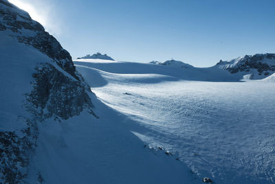 Scenic view of snowcapped mountains against blue sky