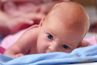 Portrait of cute baby boy lying on bed at home