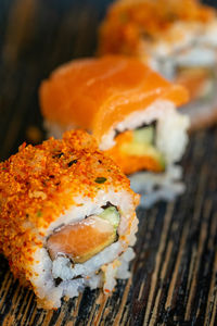 A trio of different california sushi rolls on a plate with a selection of fillings portrait close up