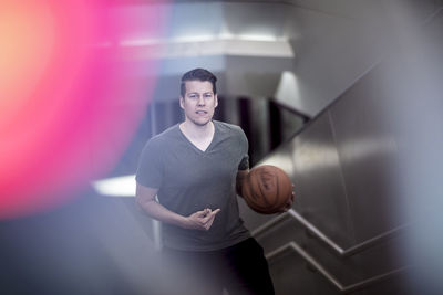 High angle portrait of young man with basketball moving up on steps