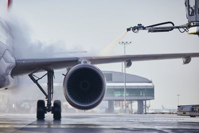 Airplane on airport runway against sky