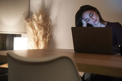 Portrait of woman using laptop at table