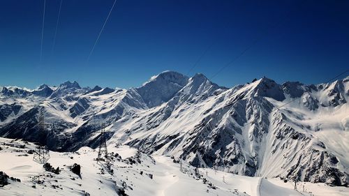 Scenic view of snowcapped mountains against clear blue sky