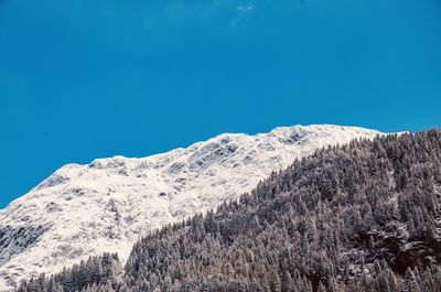 Scenic view of snowcapped mountains against clear blue sky