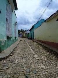 Cobblestone street amidst buildings against sky