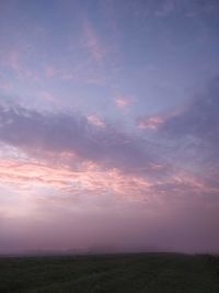 Scenic view of field against sky at sunset