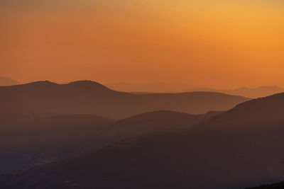 Scenic view of silhouette mountains against sky during sunset