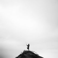 Low angle view of statue on cliff against sky