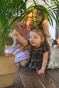 Cute girl watering plants with mother