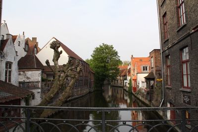 Canal amidst buildings against sky
