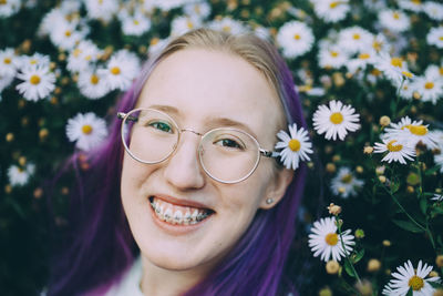 Portrait of smiling young woman with red flower