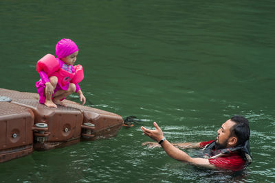 High angle view of woman with pink umbrella on lake
