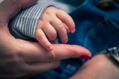 Close-up of father holding baby hand