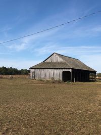 Barn on field against sky